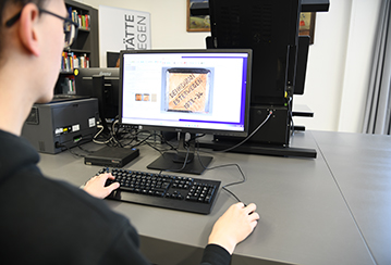 Das Foto zeigt einen Nutzer bei der Recherche am PC.